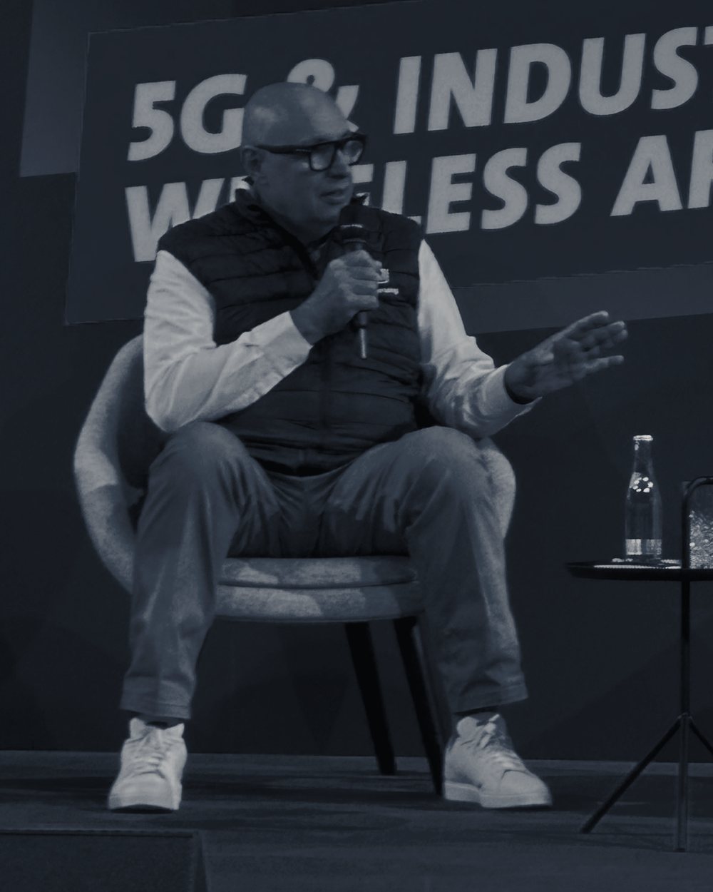 Uwe Scherf moderating a panel discussion, microphone in hand